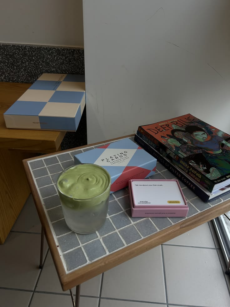 Gefliester Beistelltisch mit Matcha, Büchern und Spielkarten